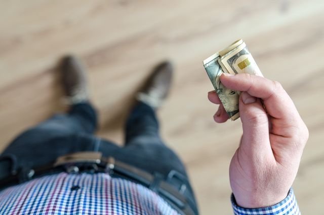 Person reviewing a weekly budget and managing personal finances